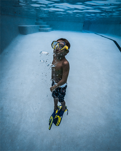 boy with goggles swimming